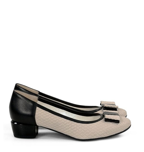 czółenka na niewysokim obcasie w kolorze jasnego beżu z czarnymi elementami. Ozdobiona modnym przetłoczeniem oraz kokardką, wykończone czarną lamówką.